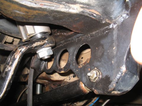 1989 Ford Bronco - Detail of a vehicle's frame showing suspension mounting points and hardware.