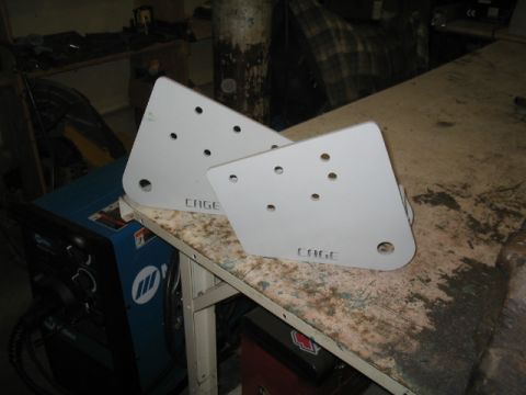 1989 Ford Bronco - Two metal brackets, possibly for a vehicle cage, are shown on a workbench.