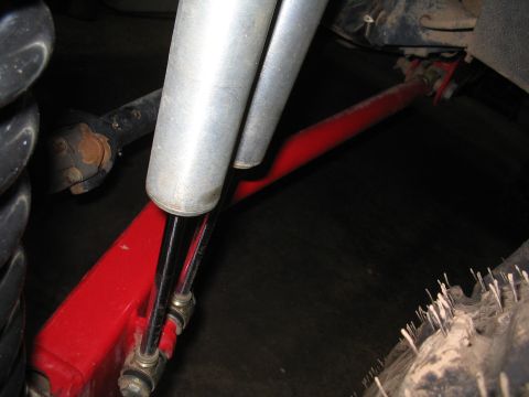 1989 Ford Bronco - Undercarriage view shows suspension parts including a red radius arm and shock absorbers.