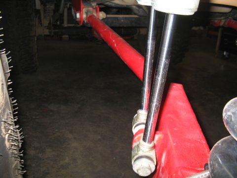 1989 Ford Bronco - The image shows a close-up view of a vehicle's suspension system, focusing on a red control arm and shock absorbers.