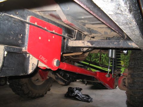 1989 Ford Bronco - Close-up view of the undercarriage, showing a red cage radius arm and suspension components.