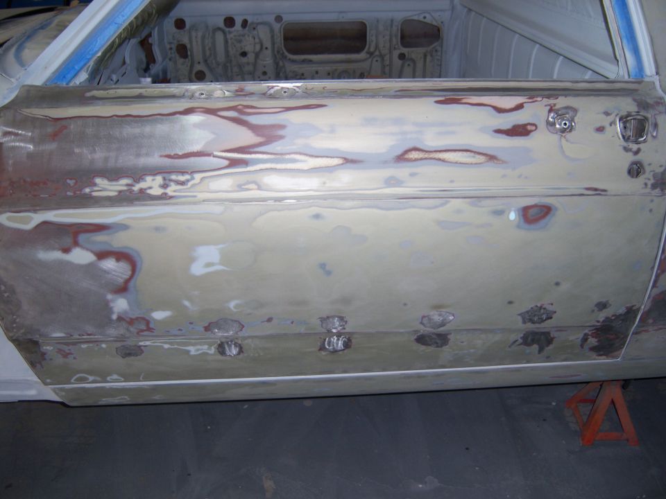 Car door with body filler and primer, showing rust repair spots