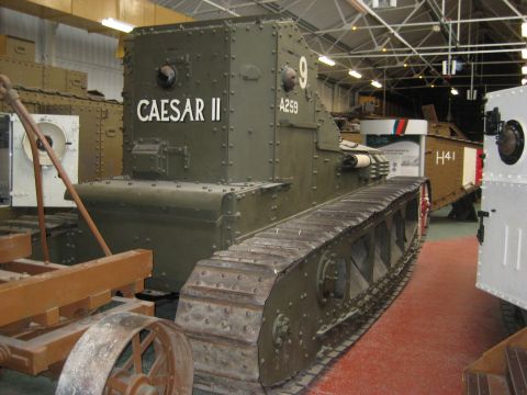 1966 Jeep CJ5 - A military tank with the designation CAESAR II is displayed indoors next to other vehicles.