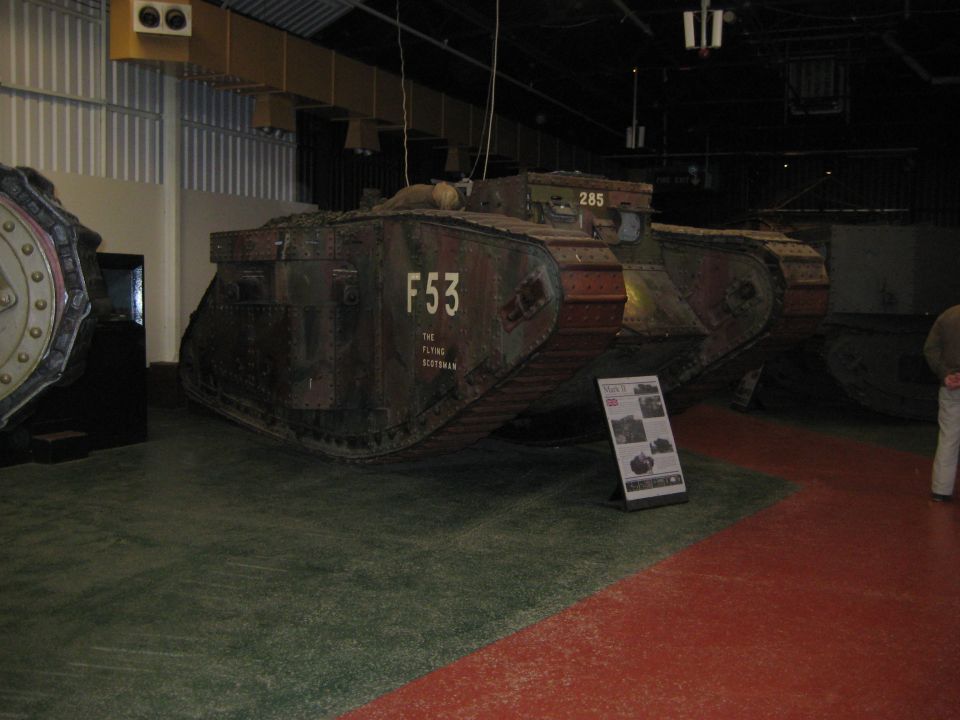 Tank with F53 marking and 'The Flying Scotsman' text, displayed in a museum with other vehicles