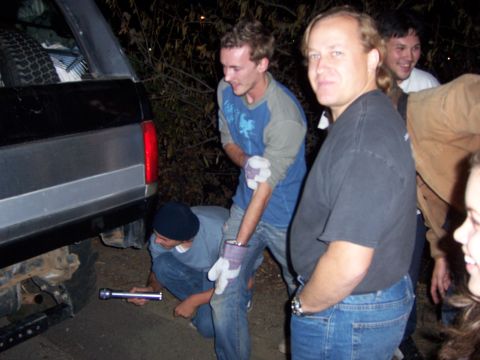 1991 Ford Bronco - A group of people are gathered around the rear of a 1991 Ford Bronco, appearing to work on it.