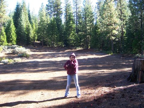 1991 Ford Bronco - A person stands in a wooded area, appearing to be cold or shielding themselves.