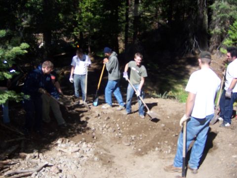 1991 Ford Bronco - A group of individuals are engaged in trail maintenance work, using shovels to shape the terrain.