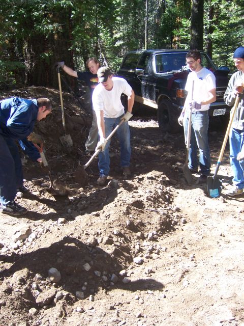 1991 Ford Bronco - Group of people digging dirt with shovels near a black 1991 Ford Bronco.