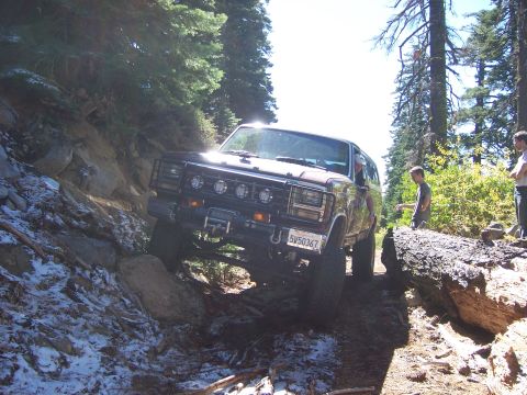 1991 Ford Bronco - A 1991 Ford Bronco tackles a challenging off-road path, demonstrating its capability on terrain.