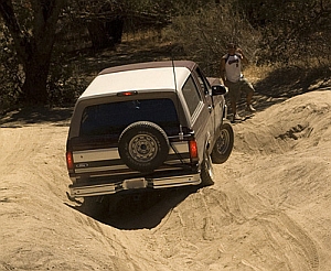 1986 Ford Bronco - This 1986 Ford Bronco is captured from the rear as it navigates a challenging off-road course.
