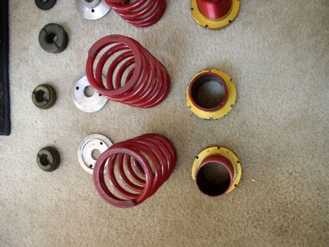 1994 Ford Probe - Various suspension springs and components, including coilover parts, are laid out on a carpeted surface.