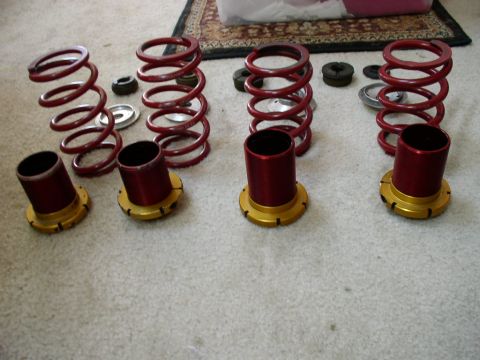 1994 Ford Probe - Suspension components, including coilover springs and shock bodies, are displayed on a carpeted surface.