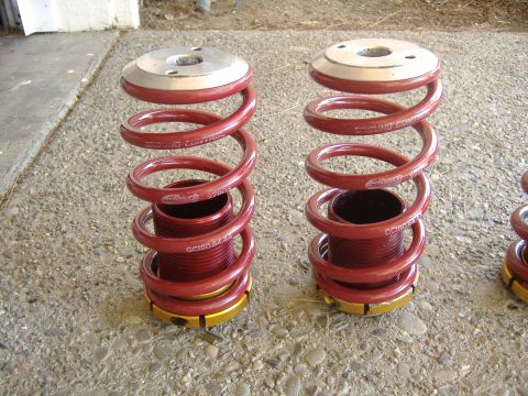 1994 Ford Probe - Two red Eibach suspension springs are shown sitting on a concrete surface.
