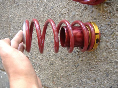 1994 Ford Probe - A red coilover suspension part is held by a hand, showing text from the manufacturer.