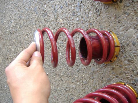 1994 Ford Probe - Close-up of a red coilover suspension spring with a hand holding its top.