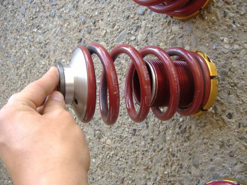 1994 Ford Probe - A close-up shows a red coilover suspension part being held, with text visible on the spring.