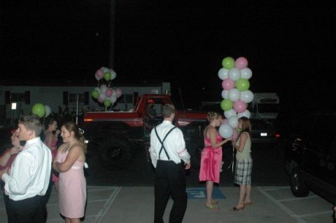 1979 Ford Bronco - A group of people gather around a red pickup truck decorated with balloons at an outdoor event.