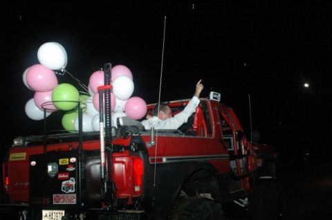 1979 Ford Bronco - Night shot of a red lifted Ford 4x4 with the top removed, a bundle of pink, white and green balloons tied to the tailgate and a tall CB whi…