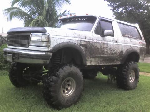 1995 Ford Bronco - This heavily modified Ford Bronco is covered in mud, indicating recent off-road use.