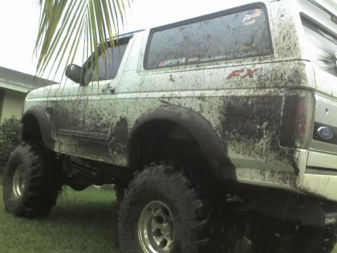 1995 Ford Bronco - Muddy 1995 Ford Bronco with aftermarket wheels and tires after off-roading.