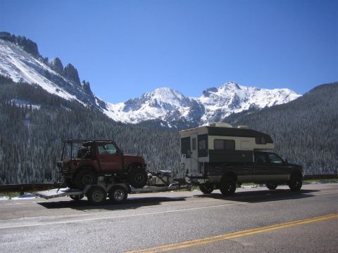 1999 Ford F-250 - Truck camper and trailer with off-road vehicle on a mountain road in Colorado.