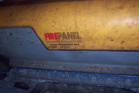 2001 Ford Crown Victoria - Close-up of a yellow panel with a label for a vehicular fire protection system.