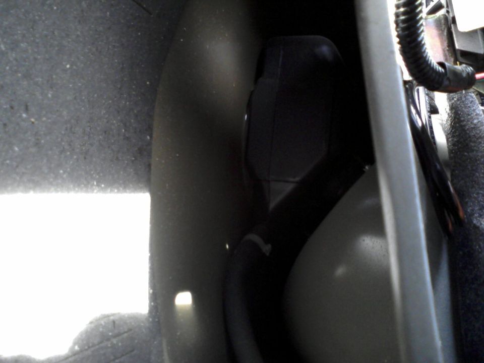 The stock NON-remote release fuel filler door opening - as viewed from in the trunk, behind the carpeting - between the fender and trunk bracing