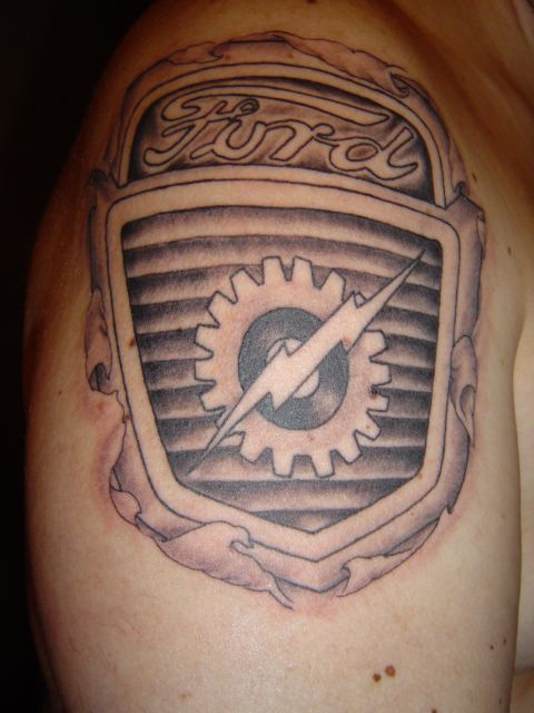 1989 Ford Bronco - A tattoo of the Ford emblem, a gear and lightning bolt, is visible on a person's shoulder.