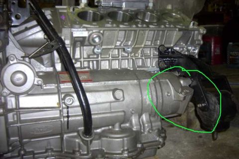 1997 Ford Taurus - Ford aluminum V6 engine and transaxle on a stand; a mounting bracket area is circled in green for reference.