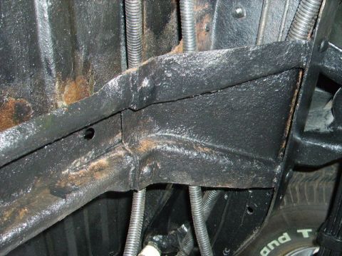 1978 Ford Bronco - Close-up view of the undercarriage, highlighting the frame and suspension system with visible signs of wear and tear.