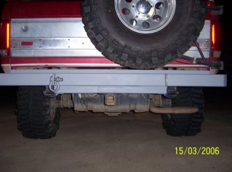 1995 Ford Bronco - Rear view of a red SUV, likely from the 1980s, with an aftermarket bumper and spare tire.