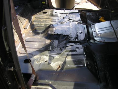 1996 Ford Bronco - Bare sheetmetal floor pan of a truck cab photographed through the open door with seats, carpet and console removed, showing ribbed stamping…