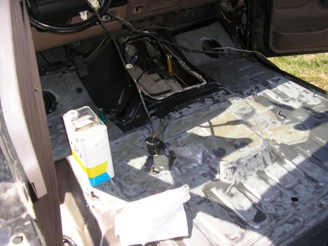 1996 Ford Bronco - Stripped interior of a truck with carpet, seats and center console removed, showing the bare stamped-steel floor pan and transmission tunne…