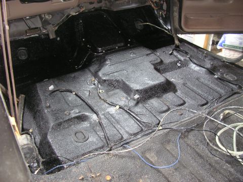 1996 Ford Bronco - Gutted interior of a truck shot from the open door, with the entire floor pan, transmission tunnel and rear cargo area coated in fresh text…