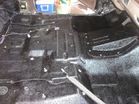 1996 Ford Bronco - Stripped truck cab floor freshly coated in textured black bedliner, shot through the open passenger door with seats and carpet still out. W…