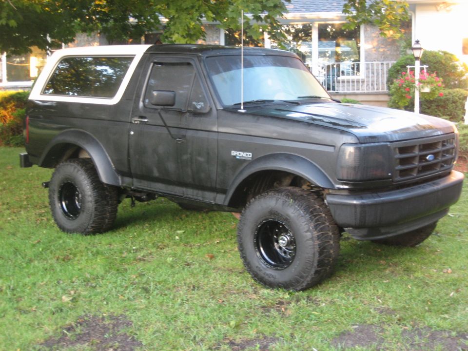 Black 1995 Ford Bronco with white removable top parked on grass