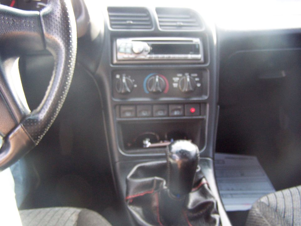 1994 Ford Probe interior showing steering wheel, dashboard, center console with radio and climate controls, and gear shifter