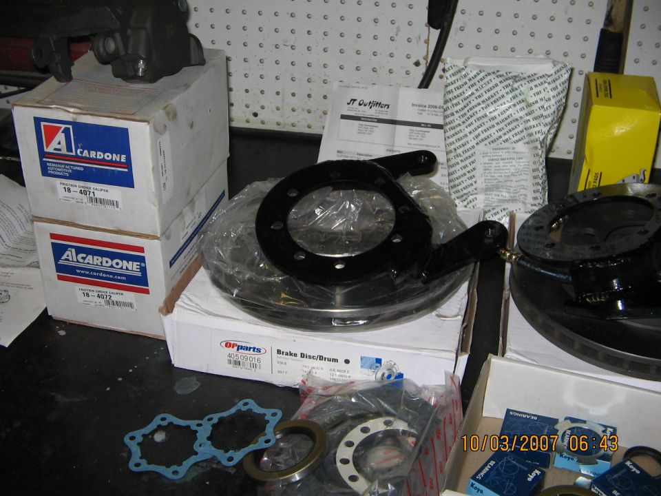 Brake disc rotor and parts boxes on a cluttered workbench
