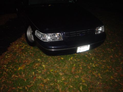 2000 Ford Crown Victoria - Front view of a 2000 Ford Crown Victoria parked on a lawn covered in autumn leaves.