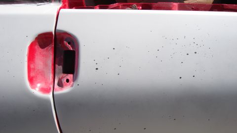 1996 Ford Probe - A close-up of a car's side panel reveals a removed fuel filler door, exposing primer and the vehicle's interior.