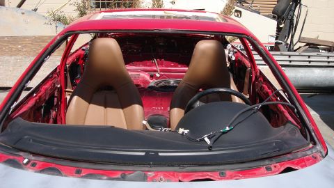 1996 Ford Probe - The interior of a red sports car is shown with its doors removed and the seats exposed.
