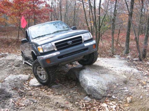 1990 Ford Bronco - Toyota Tacoma navigates a challenging rocky terrain during an off-road excursion.