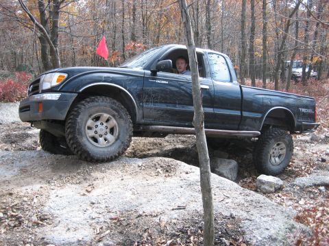 1990 Ford Bronco - A black Toyota Tacoma navigates a rocky trail, with a second vehicle visible in the distance.