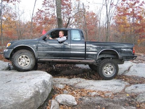 1990 Ford Bronco - Toyota Tacoma TRD Off Road model navigating rocky terrain.