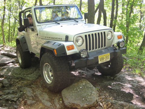 1990 Ford Bronco - Jeep Wrangler TJ navigating a challenging rocky off-road path.