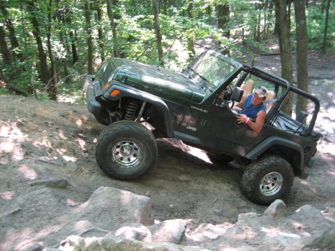 1990 Ford Bronco - Jeep Wrangler TJ tackles a challenging rocky off-road course.