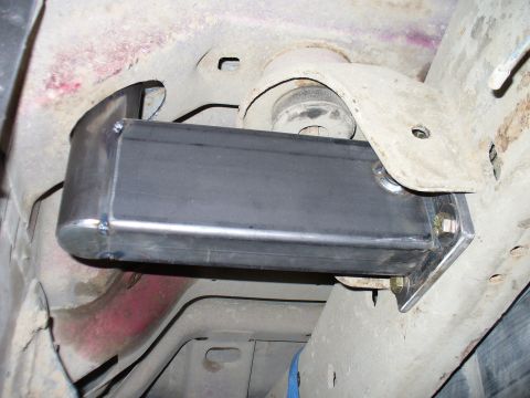 1978 Ford Bronco - Custom metal bracket installation on a vehicle's frame, near suspension parts.
