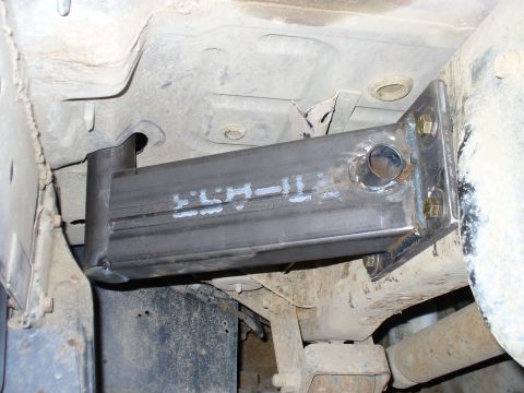 1978 Ford Bronco - Close-up view of a custom metal bracket attached to the underside of a vehicle frame.