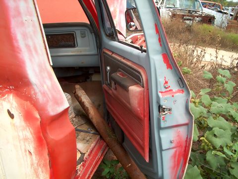 1979 Ford Bronco - View inside a derelict vehicle, with other abandoned cars in the background.
