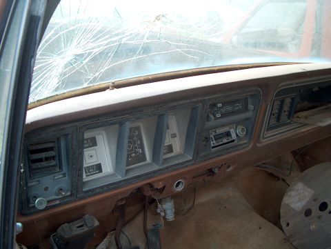 1979 Ford Bronco - The interior of a 1979 Ford Bronco shows a cracked windshield and an aftermarket radio installed in the dashboard.